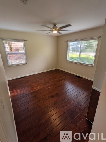 A room with wooden flooring and a ceiling fan.