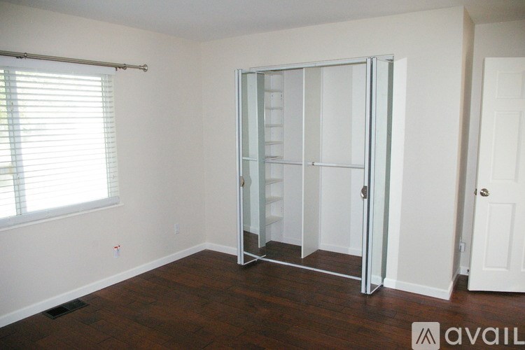 A room with a white door and a white wall with a window.