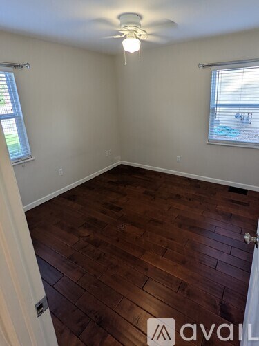 A room with wooden flooring and a ceiling fan.