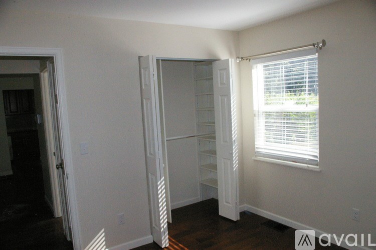 A room with a white door and a window with blinds.