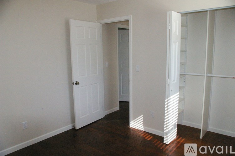 A room with a white door and a white closet with a sign that says "available".