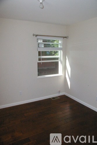 A room with a window and wooden floors.