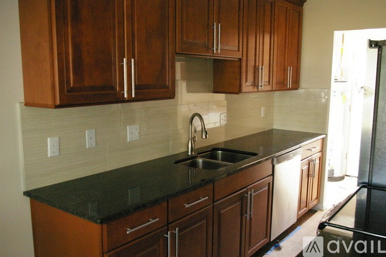 A kitchen with wooden cabinets and a black counter top.