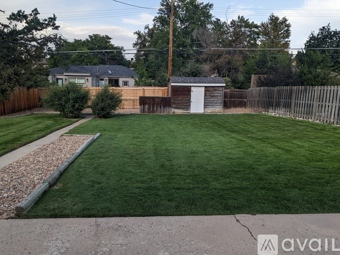 A backyard with a shed, a fence, and a well-maintained lawn.