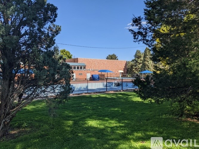 A grassy area with trees and a building in the background.