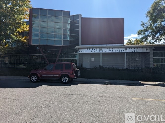 A red SUV is parked in front of a building with a sign that reads "ROSS UNIVERSITY HILLS".