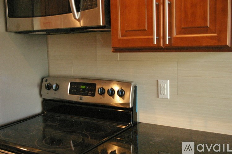 A stove with a digital display is in a kitchen.