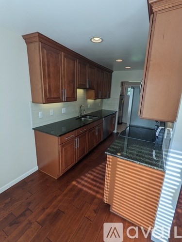 A kitchen with wooden cabinets and a black countertop.