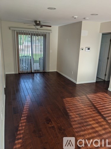A room with wooden floors and a ceiling fan.