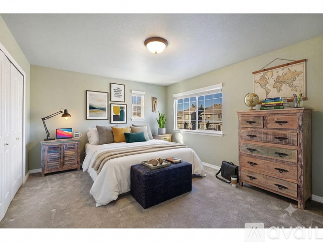 A bedroom with a bed, a dresser, and a window with a view.