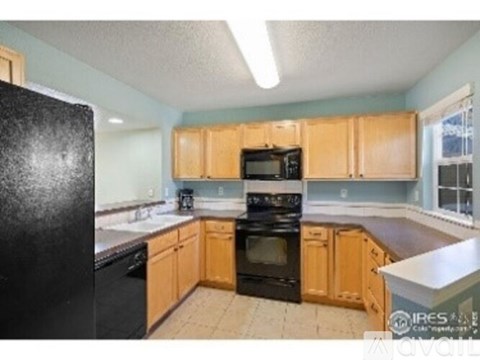 A kitchen with black appliances and wooden cabinets.
