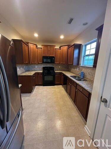 A kitchen with wooden cabinets and a black stove top oven.