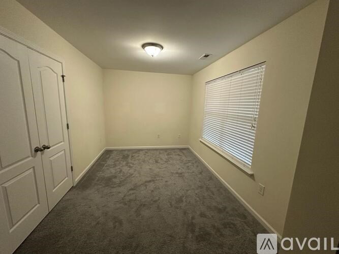 A room with a wall that is being painted and a few items on the floor.