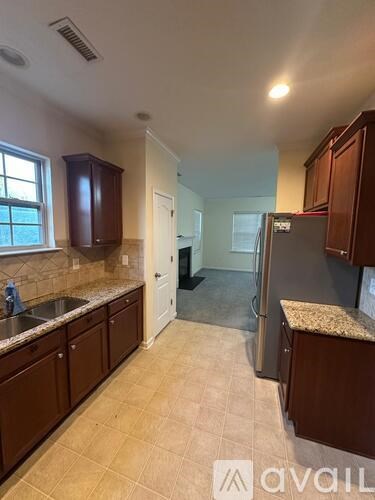 A kitchen with brown cabinets and a granite countertop.