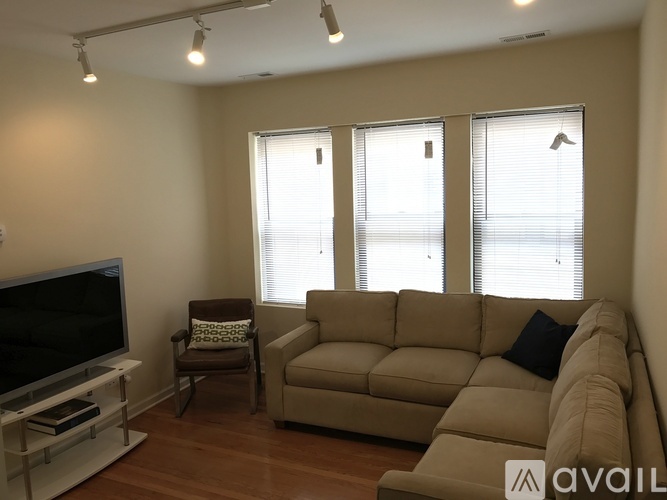 A living room with a couch, chair, and television.