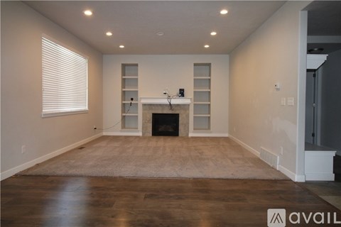 A spacious living room with a fireplace and built-in shelves.
