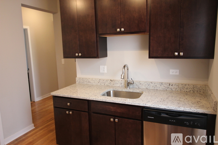 A kitchen with brown cabinets and a white sink.