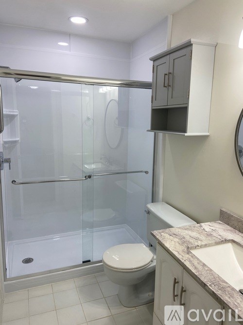 A bathroom with a toilet, sink, and shower.