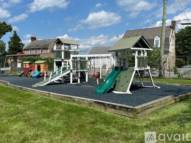 A playground with a green slide and a wooden structure.