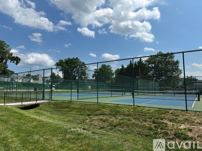 A tennis court is enclosed by a chain-link fence.