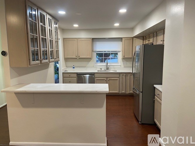 A kitchen with a white countertop and a refrigerator.