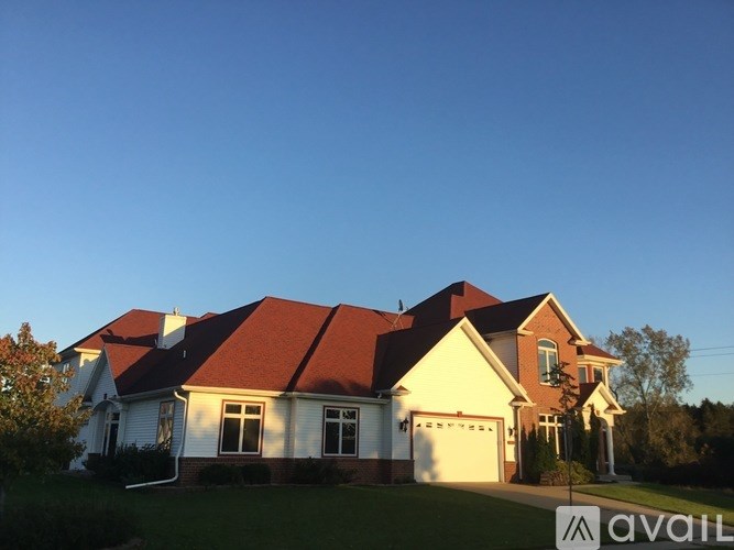 A house with a red roof and a sign that says "available" in front of it.