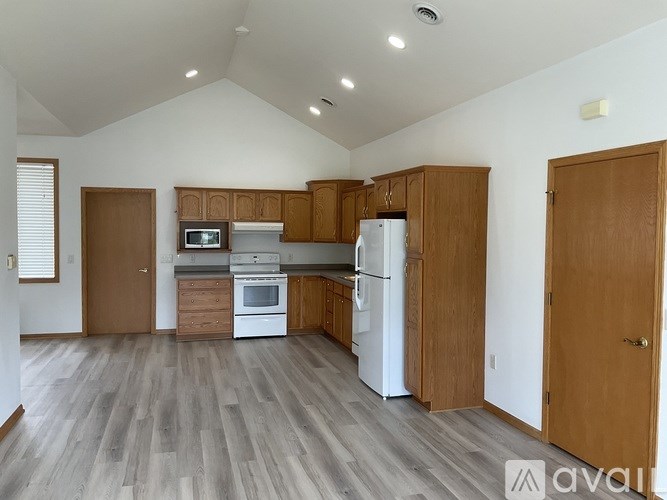 A kitchen with wooden cabinets and a white fridge.