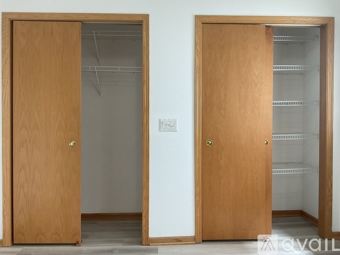 Two wooden doors, one open, one closed, in a room.