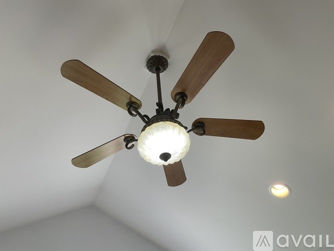 A ceiling fan with a light fixture in the middle of it.