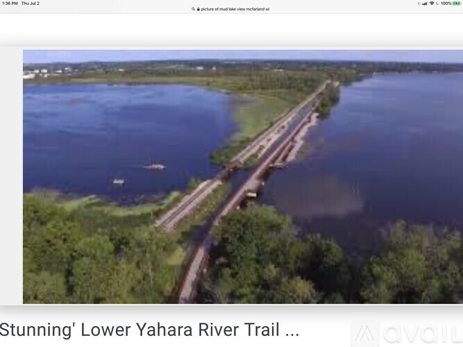 A scenic view of the Lower Yahara River Trail with a bridge crossing over the water.