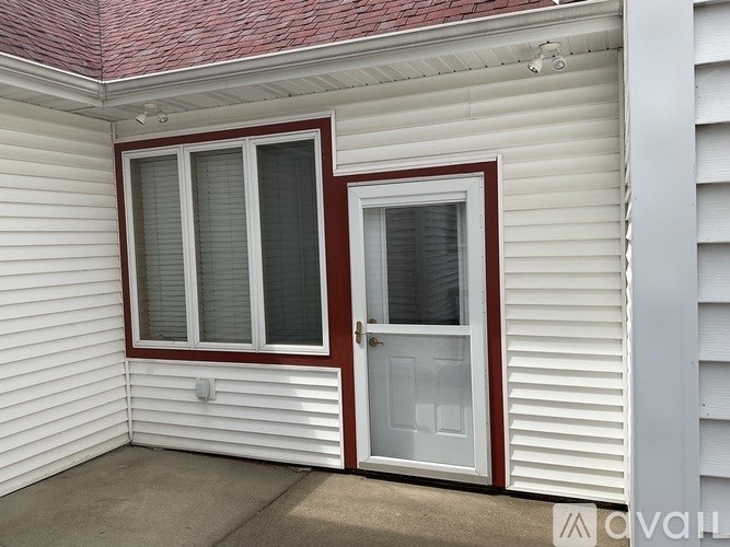 A white house with a red roof and a white door.