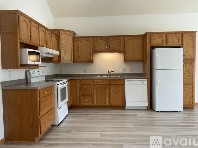 A kitchen with wooden cabinets and white appliances.