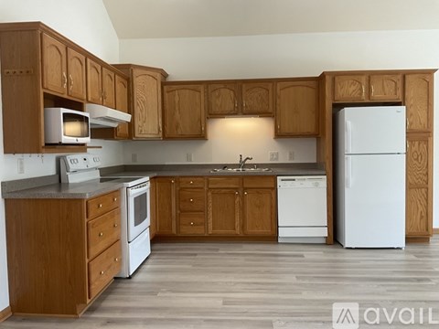 A kitchen with wooden cabinets and white appliances.