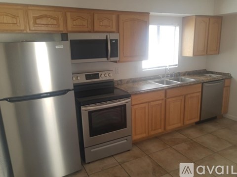 A kitchen with wooden cabinets and a stainless steel refrigerator.