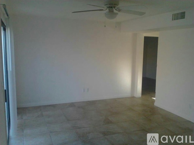 A room with a ceiling fan and tiled floor.