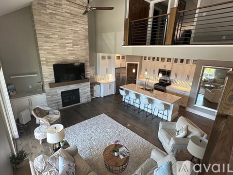 A living room with a stone fireplace and a television above it.
