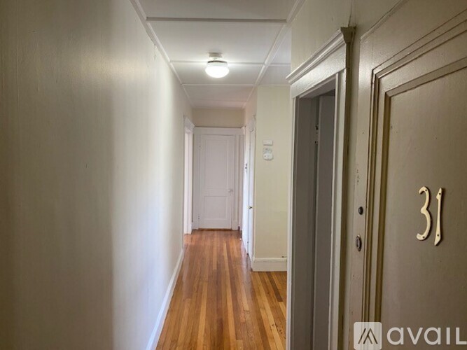 A hallway with wooden floors and a door with the number 31 on it.