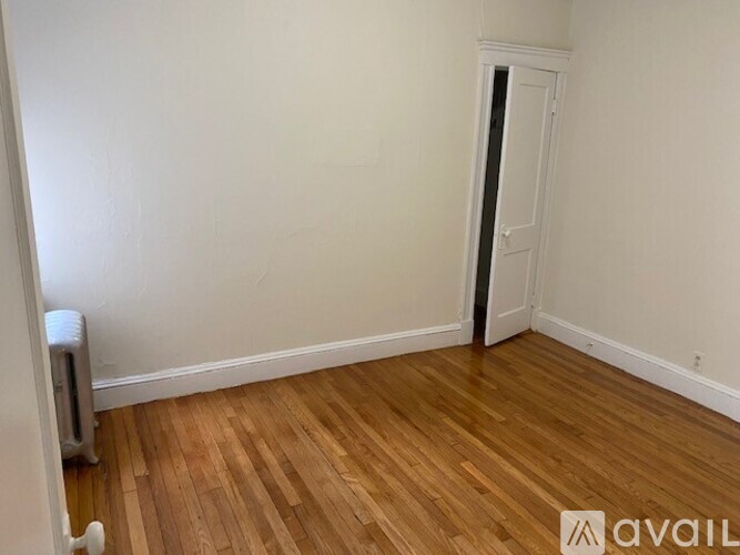 A room with wooden flooring and a white door.