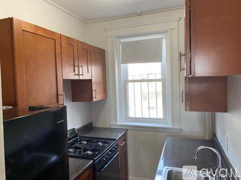 A kitchen with wooden cabinets and a black stove top oven.
