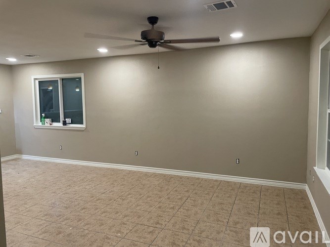 A room with a ceiling fan and a window.