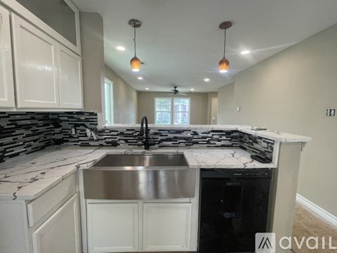 A kitchen with a marble countertop and a stainless steel dishwasher.