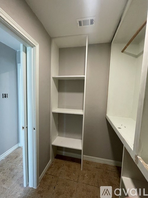 A white closet with shelves and a door.