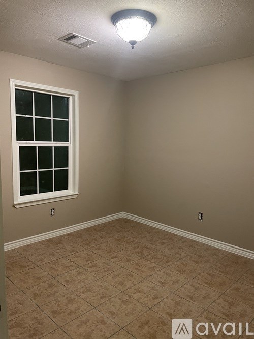 A room with a window and tiled floor.