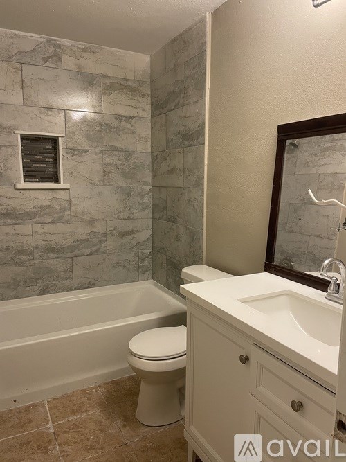 A bathroom with a toilet, sink, and tub.