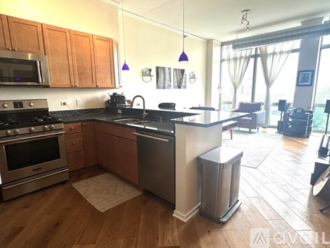 A kitchen with wooden cabinets and a black countertop.