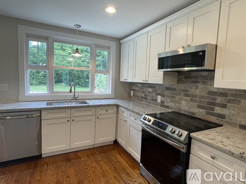 A kitchen with white cabinets and a black stove top oven.