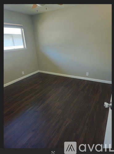 A room with wooden flooring and a window.