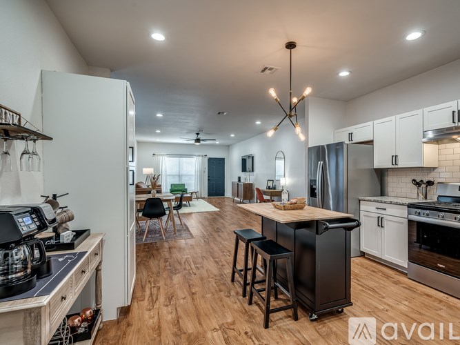 A modern kitchen with a wooden floor and white appliances.