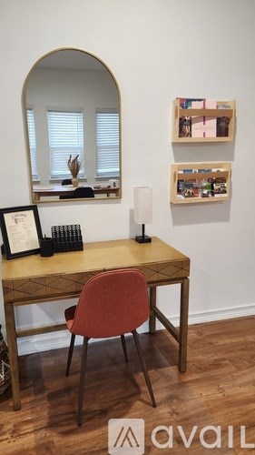 A desk with a chair and a mirror in a room.