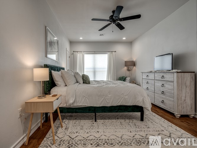 A bedroom with a bed, nightstand, and a ceiling fan.
